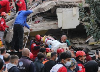 Rescuers and local volunteers carry a wounded victim on a stretcher from a collapsed building after a powerful earthquake struck Turkey's western coast and parts of Greece, in Izmir, on October 30, 2020. - A powerful earthquake hit Turkey and Greece on October 30, killing at least six people, levelling buildings and creating a sea surge that flooded streets near the Turkish resort city of Izmir. (Photo by - / IHLAS NEWS AGENCY / AFP) / Turkey OUT