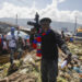 FILE - Barbecue, the leader of the "G9 and Family" gang, stands next to garbage to call attention to the conditions people live in as he leads a march against kidnapping through La Saline neighborhood in Port-au-Prince, Haiti, Friday, Oct. 22, 2021. The group said they were also protesting poverty and for justice in the slaying of President Jovenel Moise. (AP Photo/Odelyn Joseph, File)