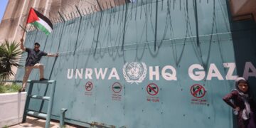 A protester holds a flag outside the United Nations Relief and Works Agency (UNRWA) during the demonstration. The Palestinian refugees' councils organize a demonstration to support the UNRWA which coincides with the convening of the Consultative Committee and the donor and refugee-hosting countries in Beirut.