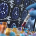 United Kingdom, High Wycombe, Alzheimer's and Dementia Research, Scientist holding a blood sample during a clinical trial with a MRI on screen