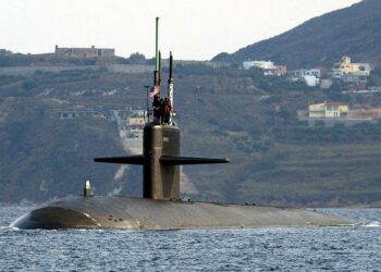 Port bow view showing US Navy (USN) Sailors manning a topside watch aboard the Los Angeles Class Attack Submarine USS NEWPORT NEWS (SSN 750), as the ship departs the harbor at Souda Bay, Crete, Greece following a port visit.